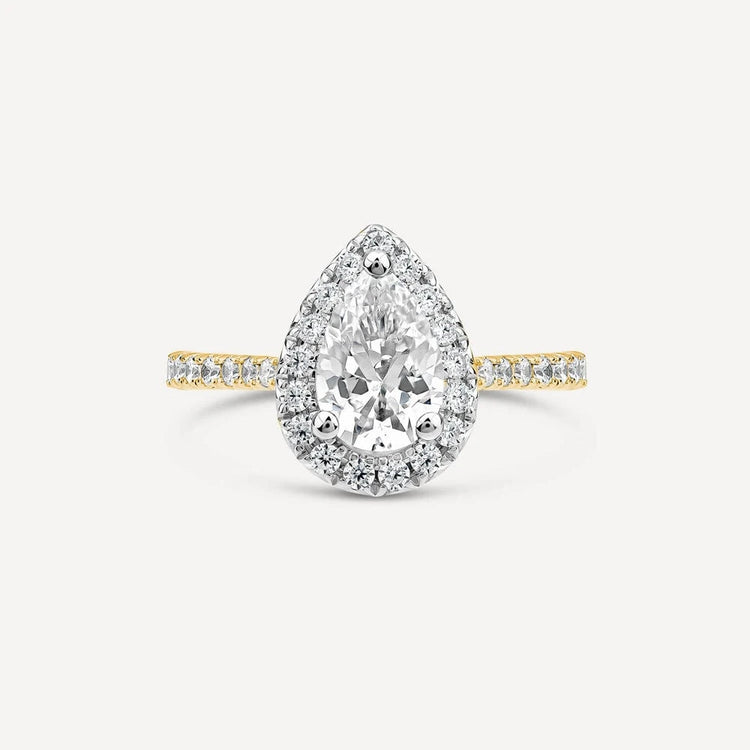 Pear-shaped diamond ring with a halo setting, set on a yellow gold band accented with pavé diamonds.